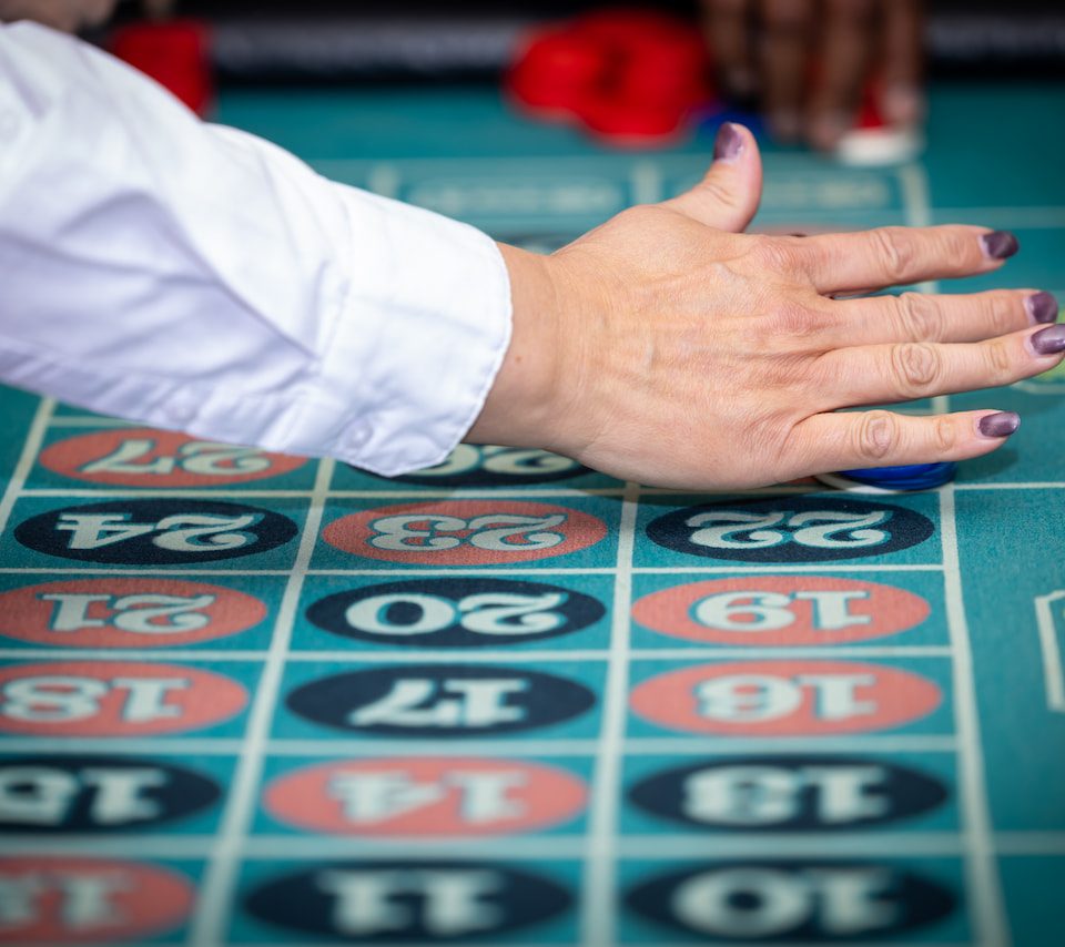 Person placing a bet on a number at a roulette table.